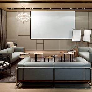 Stilvolle Lounge im Roomers Baden-Baden mit modernem Sofa, Wandpaneelen und warmem Ambientelicht.